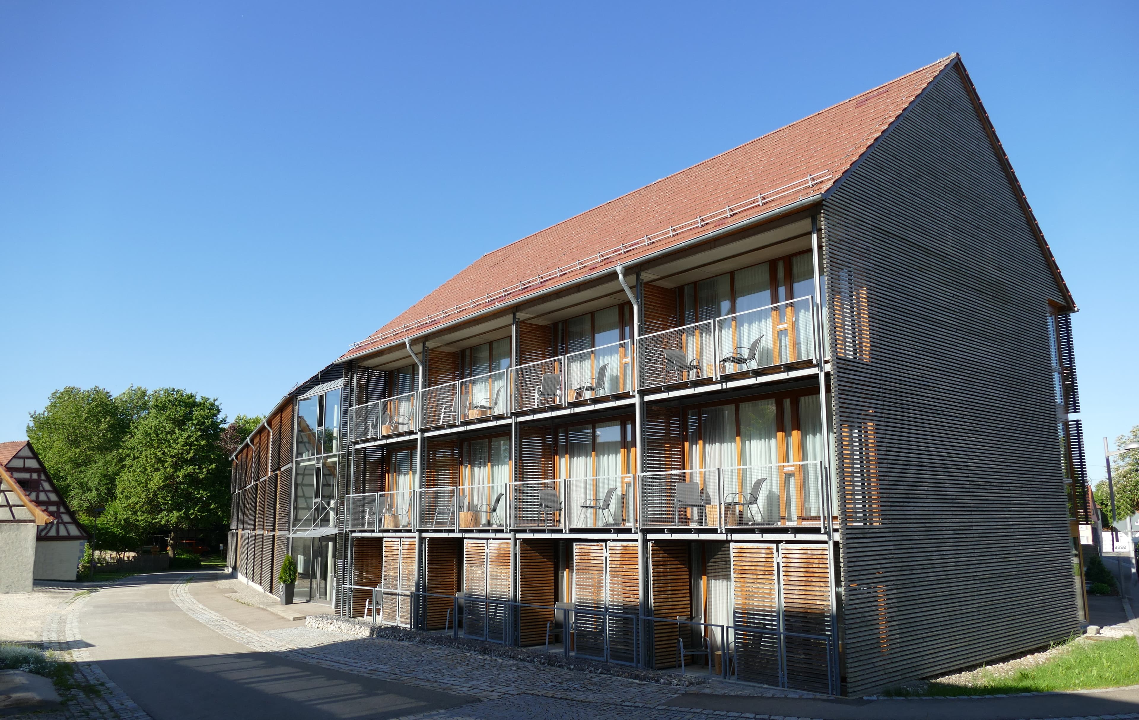 Außenansicht von Speidel’s BrauManufaktur in Hohenstein-Ödenwaldstetten mit modernem Hotelgebäude und Balkonen.