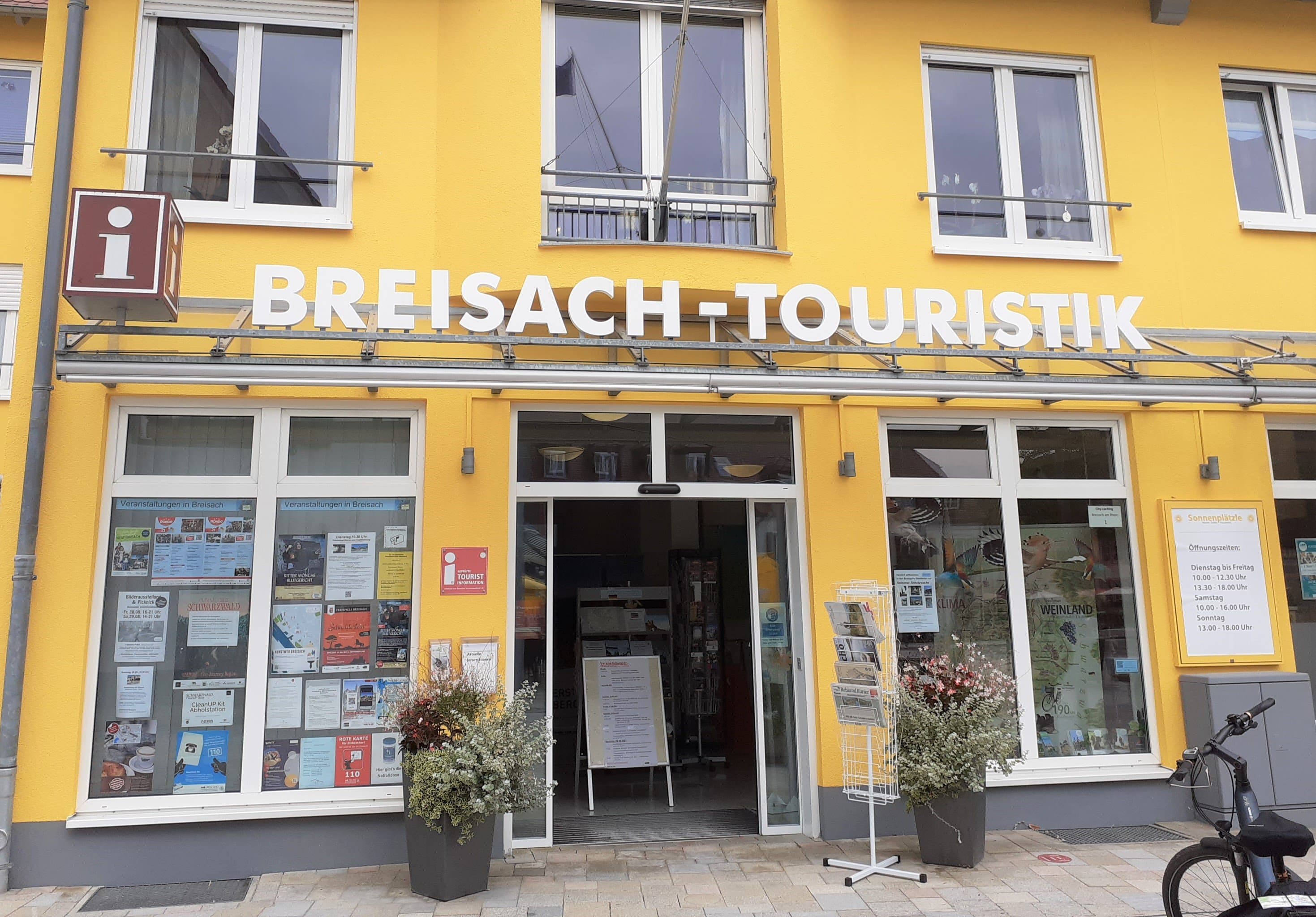 Gelbes Gebäude mit der Aufschrift Breisach-Touristik in weiß.