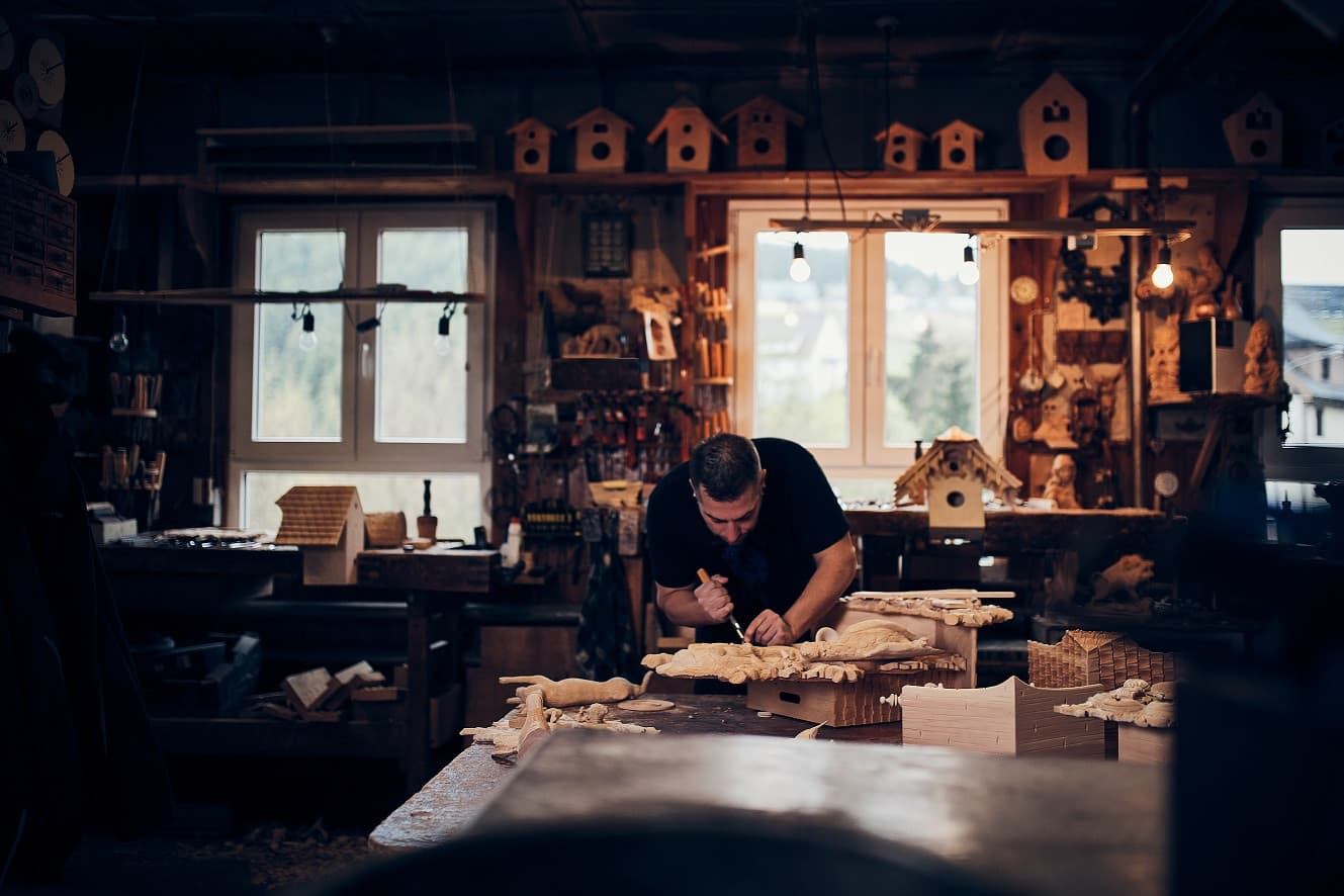 Urige, dunkle Werkstatt, in der ein junger Mann arbeitet