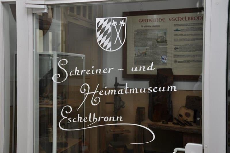 Eingangsfenster mit weißem Schriftzug und Wappen des Museums