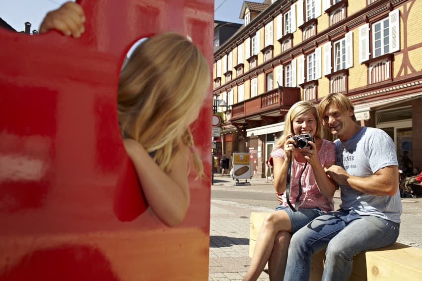 Das Bild zeigt eine Familie beim Fotografieren ihrer Tochter.