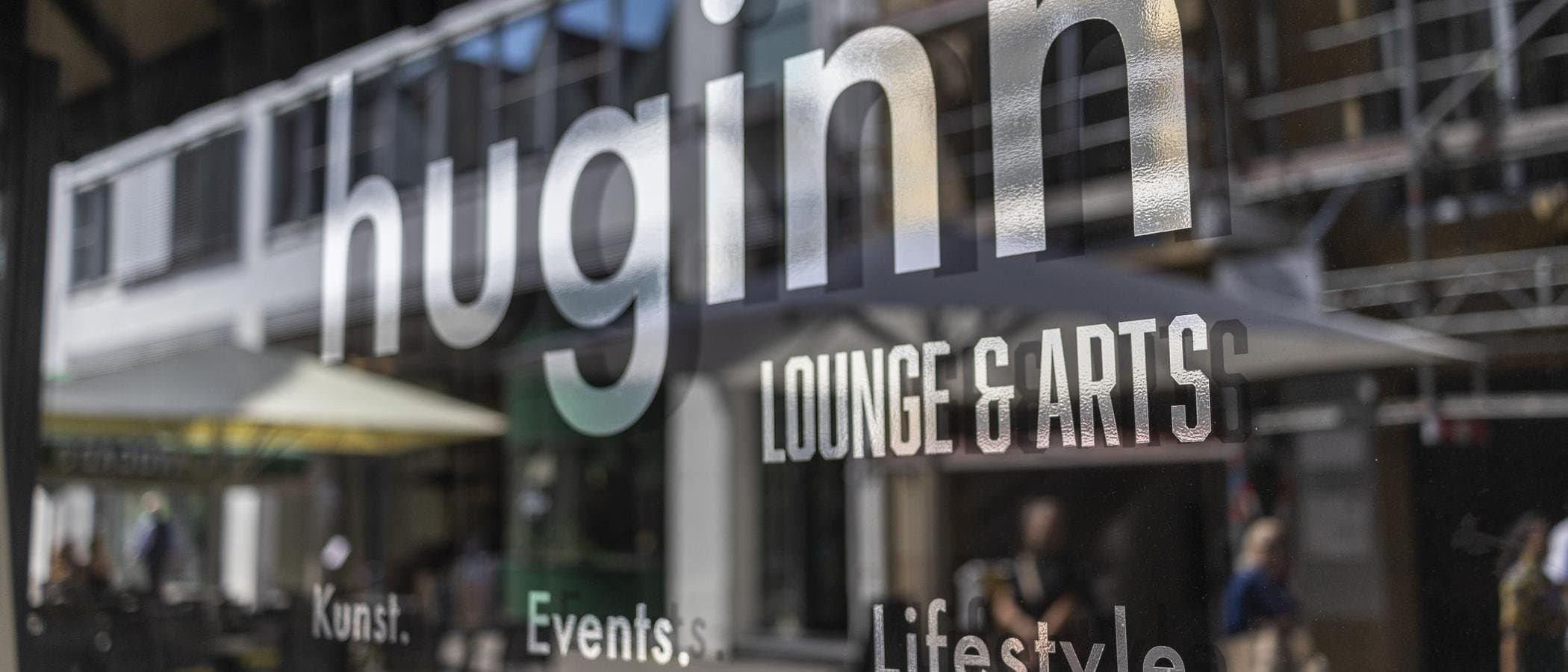 Spiegelung eines Schriftzugs auf einer Glasoberfläche mit dem Wort 'huginn'.