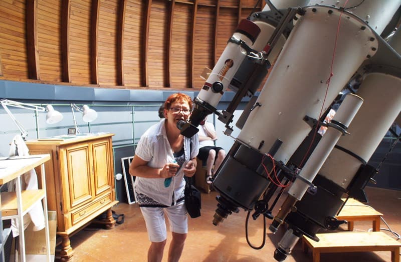 Eine Frau sieht durch das große Fernrohr in der Sternwarte Tübingen.