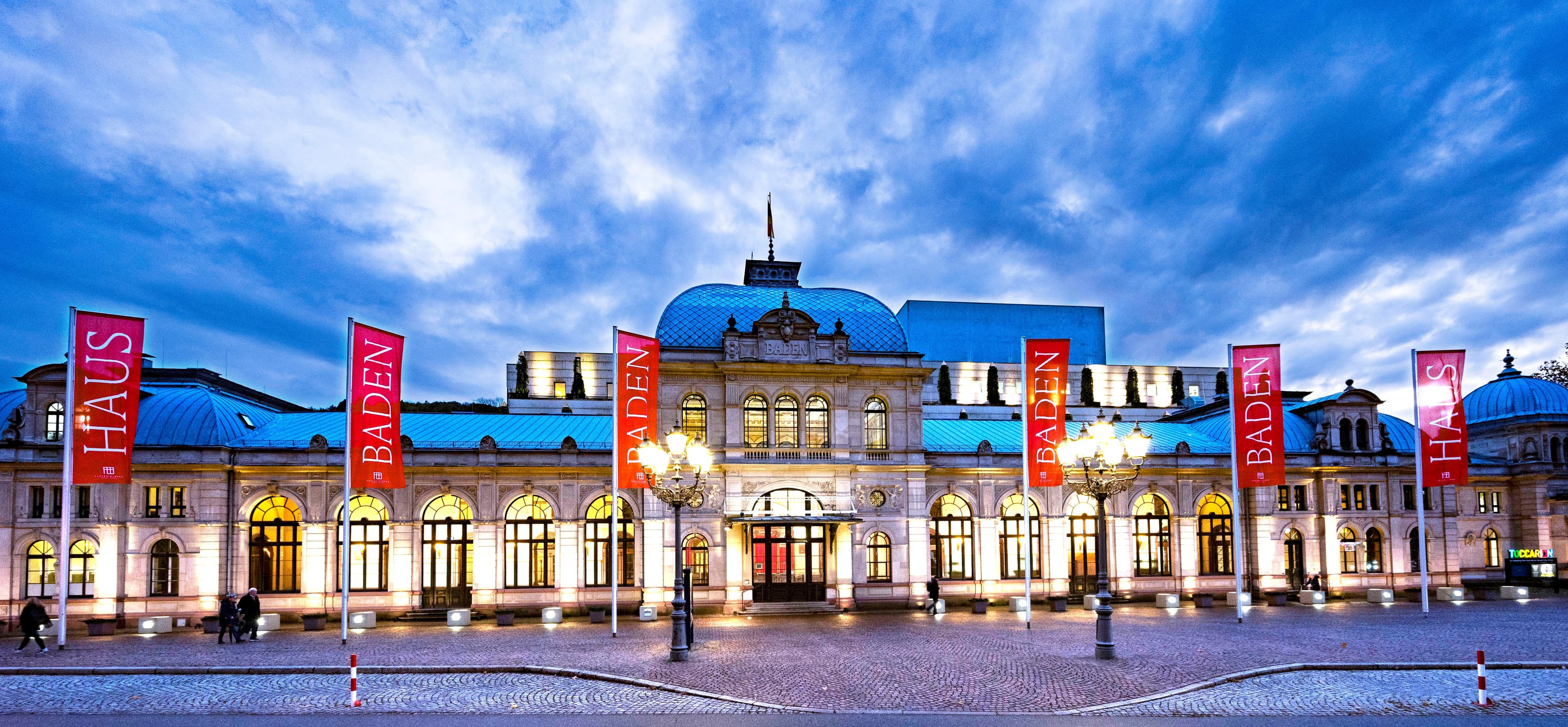 "Festspielhaus Baden-Baden" at dusk, red flags in the foreground