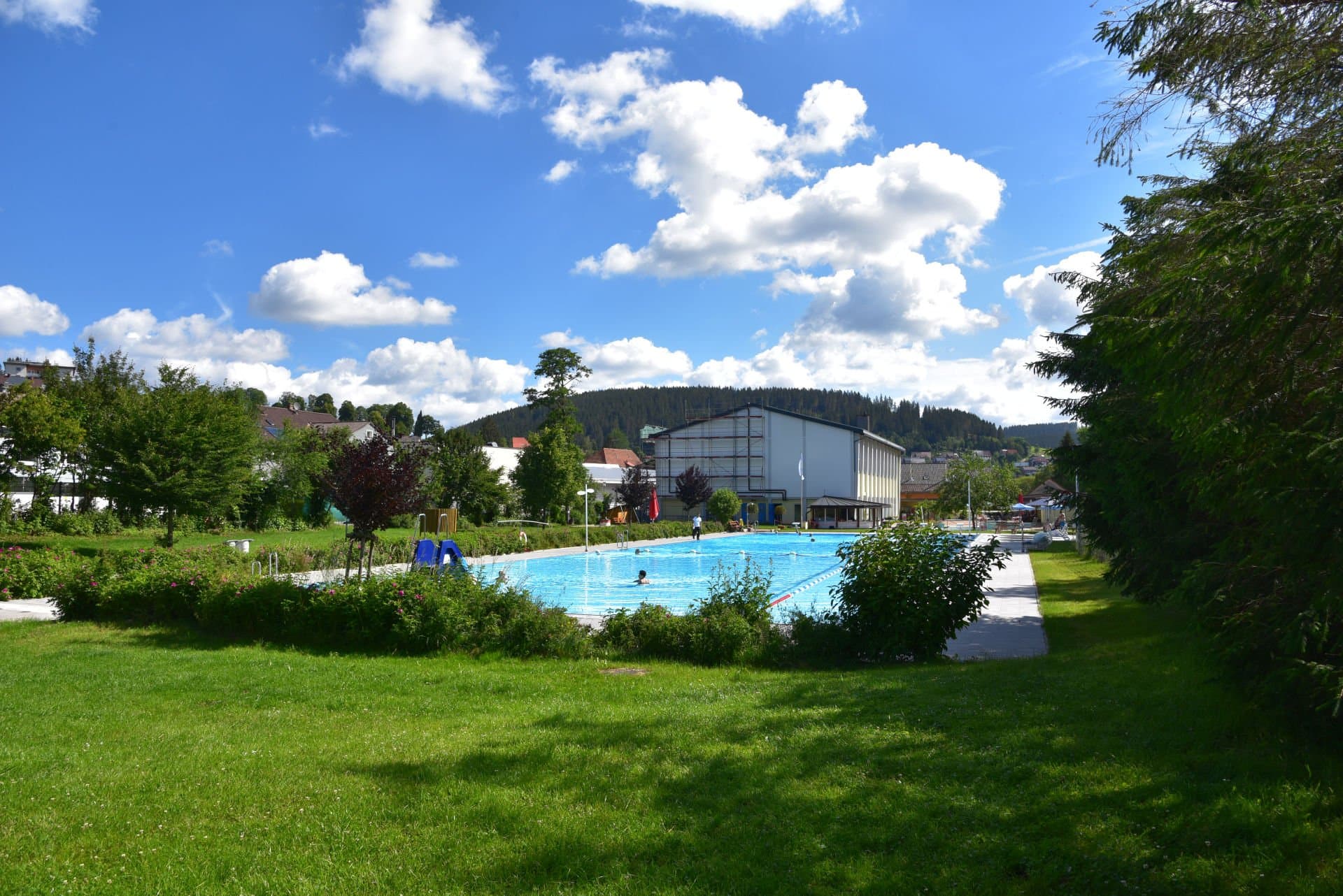 Großes Schwimmerbecken im Bregatalbad Furtwangen mit Liegewiese drum herum