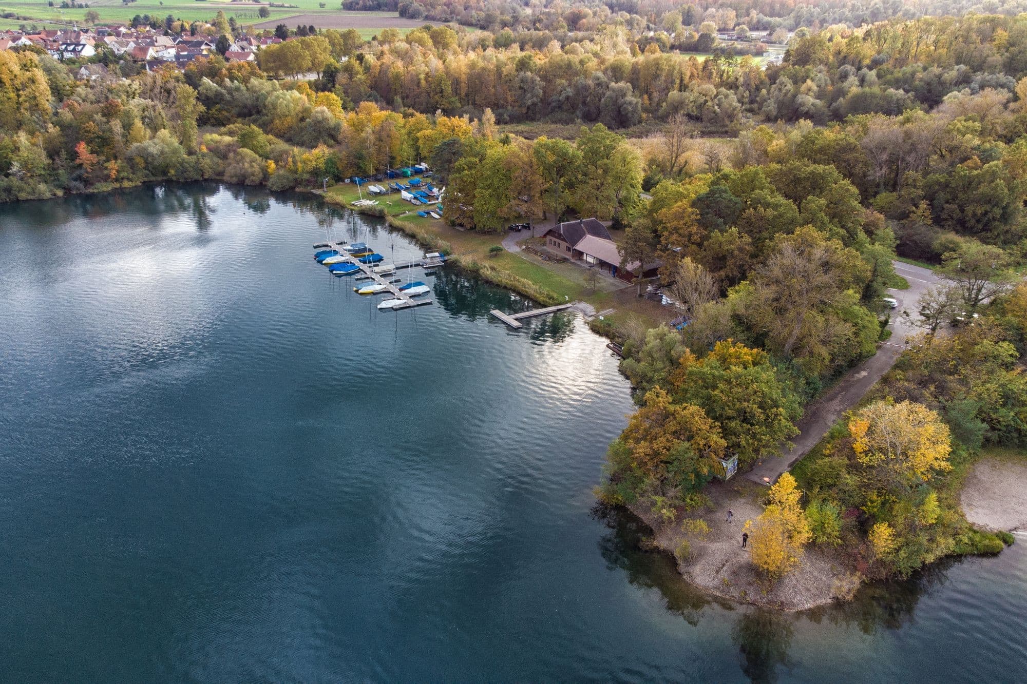 Bird's-eye view of the lake and forest, sailboats moored at the shore