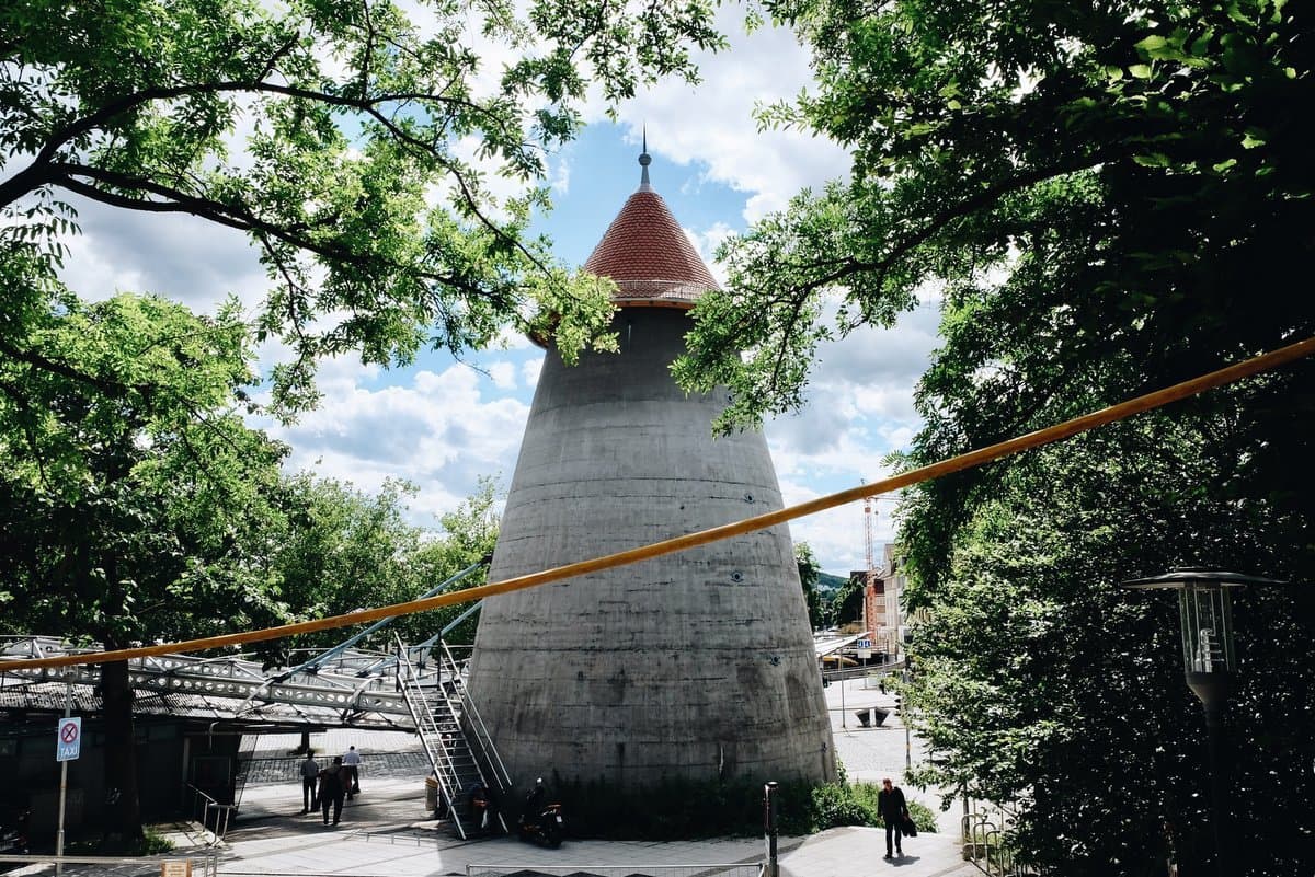 Ein Winkelturm in einem parkähnlichen Umfeld mit Bäumen und einem blauen Himmel im Hintergrund.