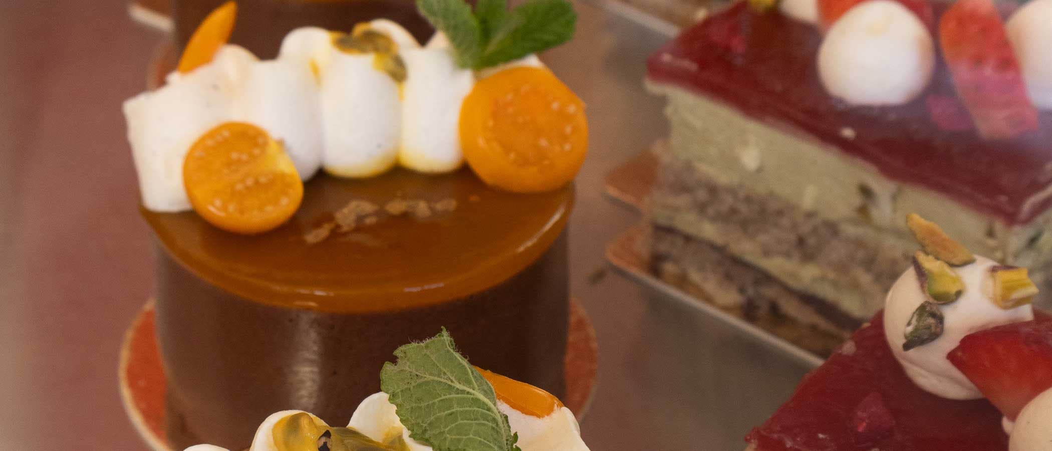 Nahaufnahme von verschiedenen dekorierten Kuchen in einer Vitrine.