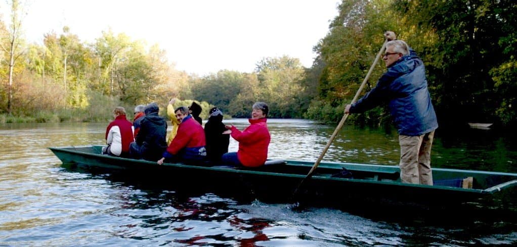Flachboot mit Menschen mit Bäumen