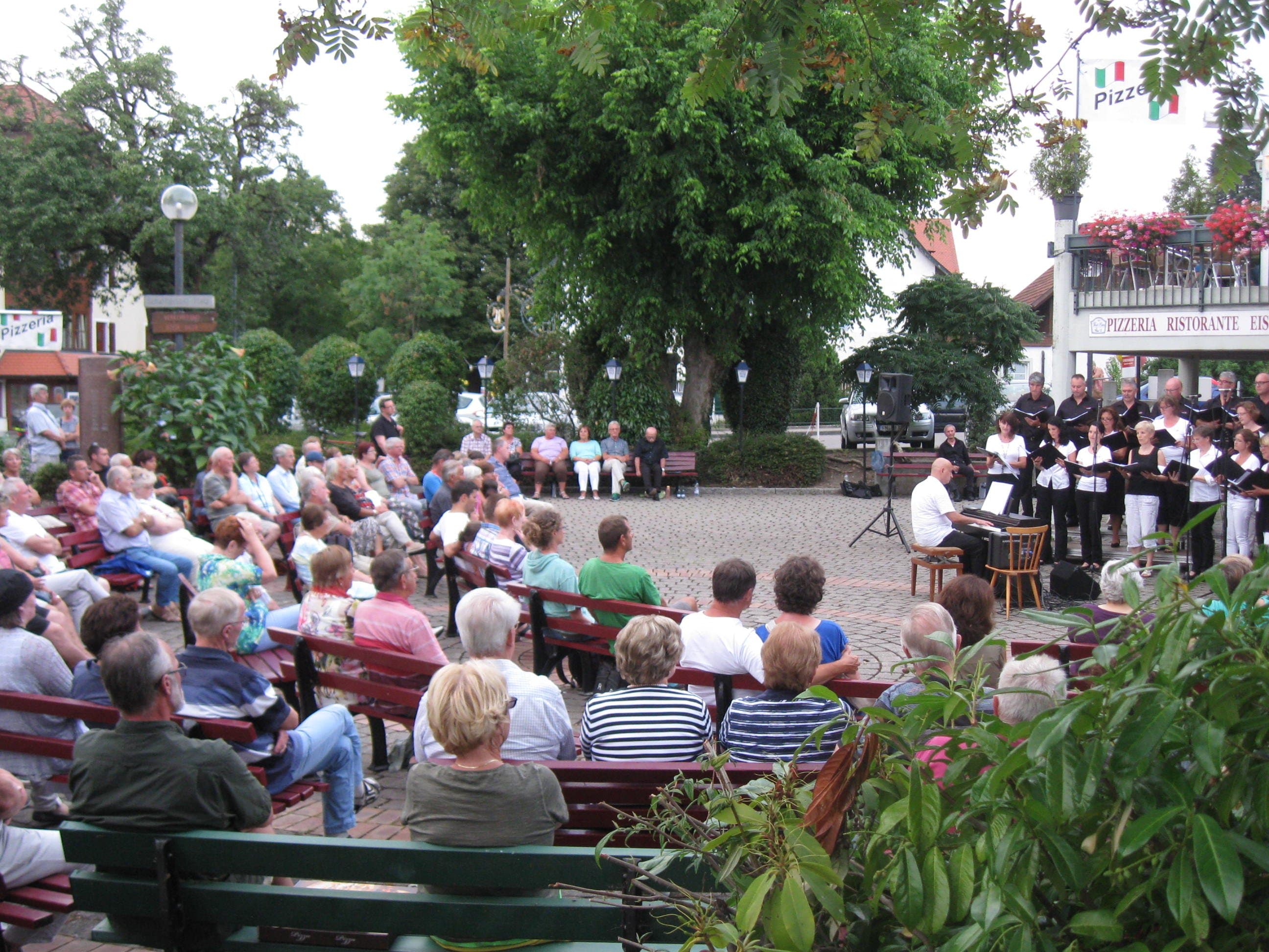 Konzert am Schäfflerplatz in Nonnenhorn  mit vielen Zuhörern, es singt ein Chor.