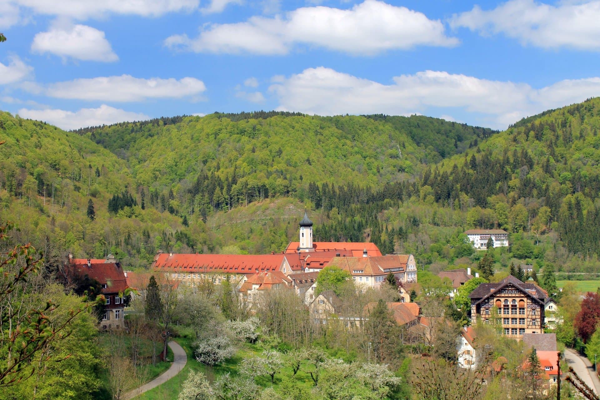 Blick vom Wanderweg auf Beuron mit Kloster und historischen Gebäuden, umgeben von bewaldeten Hängen