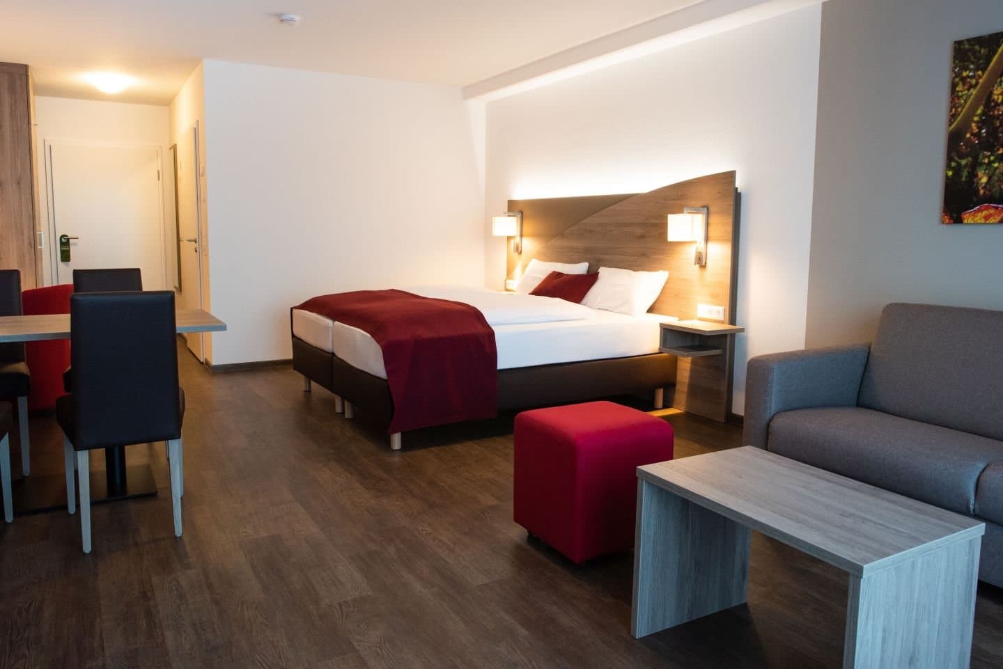 Hotelzimmer mit Doppelbett, Couch und kleiner Essecke