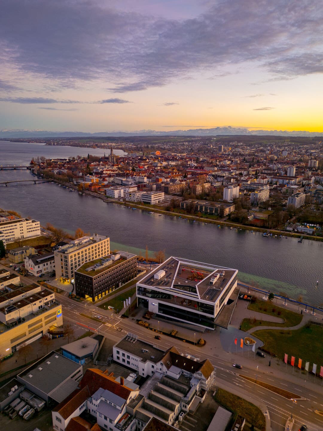 Luftbild kurz nach Sonnenuntergang mit Blick auf Bodenseeforum, Rhein und die Alpen.