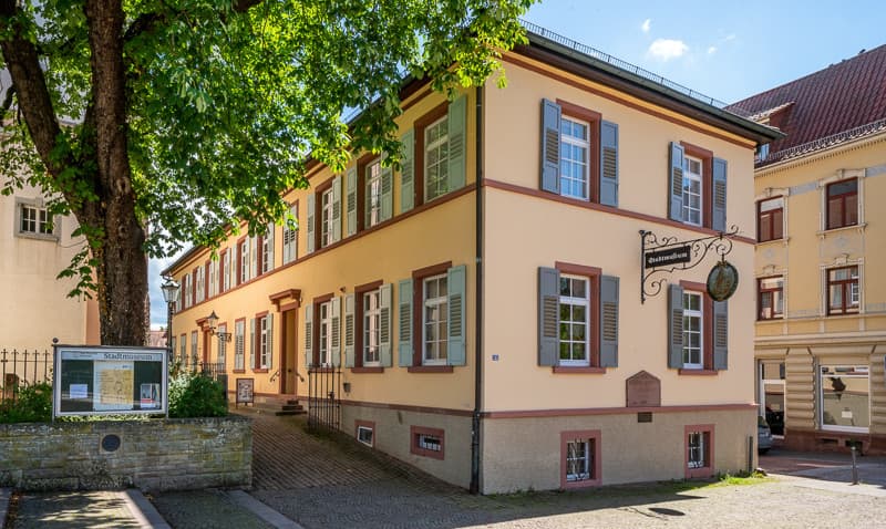 Gebäude mit hellen, freundlichen Farben und altem Metalschild